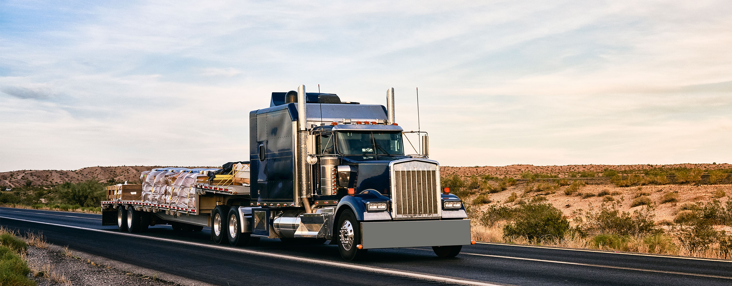Flatbed truck transporting various types of freight on USA highway