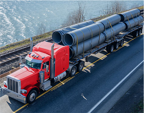 Red flatbed equipment carrying industrial freight